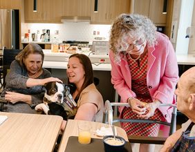 (de gauche à droite) La technicienne en travail social, Valérie Brien, technicienne en travail social, échange avec les résidents avec la participation d’Ernest, intervenant canin.